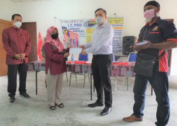 ANTHONY Loke Siew Fook (dua dari kanan) menyampaikan bantuan banjir kepada salah seorang penduduk yang terjejas pada majlis di Balai Raya Kampung Sungai Jai, Lenggeng, Seremban hari ini.-UTUSAN/BADRUL HAFIZAN MAT ISA