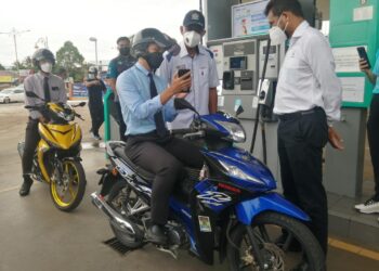 ROSOL Wahid (dua dari kanan) beramah mesra dengan penunggan dalam Kempen Keselamatan Pengguna di Stesen Minyak Petronas Kuala Berang di Hulu Terengganu, hari ini. - NOOR HAYATI MAMAT
