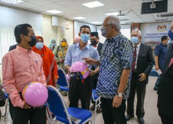 MAHDZIR  Khalid menyerahkan buku kepada seorang guru pada Majlis Penyerahan Buku dan Topi Keledar Sumbangan Yayasan Perintis Malaysia di Pejabat Pendidikan Daerah Padang Terap di Kuala Nerang, Padang Terap hari ini. - UTUSAN/SHAHIR NOORDIN