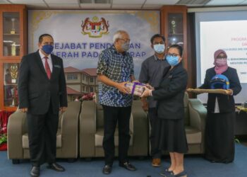 MAHDZIR  Khalid (tengah) menyampaikan sumbangan buku dan topi keledar kepada salah seorang guru besar pada Majlis Penyerahan Buku dan Topi Keledar Sumbangan Yayasan Perintis Malaysia di Kuala Nerang, Padang Terap hari ini. - UTUSAN/ SHAHIR NOORDIN