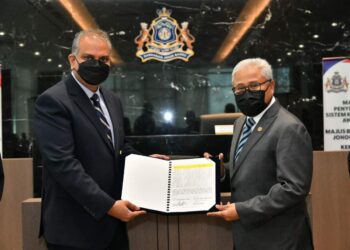 MOHD. Noorazam Osman (kanan) membuat simbolik penyerahan pengoperasian loji rawatan kumbahan awam kepada IWK di Menara MBJB, Johor Bahru.