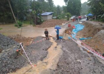 AIR melimpah dan merosakkan jalan raya antara Kampung Pamah Rawas ke pekan kecil Dong berikutan banjir kilat di Ulu Dong di Raub, Pahang. - UTUSAN/HARIS FADILAH AHMAD