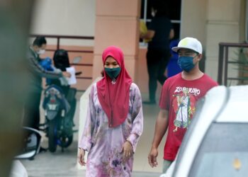 NOR Shahida Saidin (kiri) menuntut jenazah suaminya di Jabatan Forensik HRPB Ipoh hari ini. - UTUSAN/MOHAMAD HAFIZI MOHD. SAID