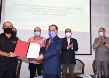 RONALD Kiandee (kiri) menyerahkan surat pemberian kuasa perikanan laut dalam kepada Jeffrey Kitingan (tiga kiri) sambil disaksikan oleh Hajiji Noor (dua kiri), Maximus Ongkili (dua kanan) dan Wan Junaidi Tuanku Jaafar (kanan) di Mini Auditorium DUN di Kota Kinabalu hari ini.