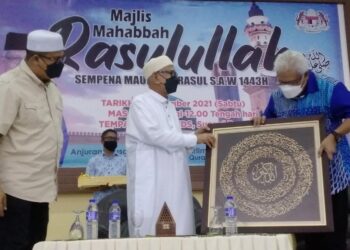 HAMZAH Zainudin (kanan) menyampaikan cenderahati kepada Abdul Hadi Awang pada Program Mahabbah Rasulullah SAW sempena Maulidur Rasul di Sungai Bayor, Selama di  Larut hari ini. - UTUSAN/WAT KAMAL ABAS