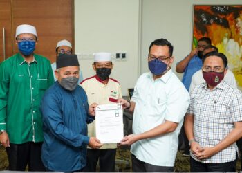 TUAN Ibrahim Tuan Man (dua dari kiri) menyampaikan watikah calon kepada calon Pas bagi Dun Beting Maro, Mohammad Arifiriazul Paijo yang turut disaksikan oleh Pesuruhjaya Pas Sarawak, Jofri Jaraiee (tengah) sempena Pilihan Raya Negeri Sarawak. - UTUSAN/MUHAMAD IQBAL ROSLI