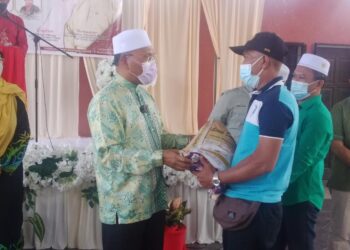 IDRIS  Ahmad (dua dari kiri) menyampaikan bantuan kepada penerima di Majlis Forum Erti Hidup di Kampung Masjid Ijok dekat Larut hari ini. - UTUSAN/WAT KAMAL ABAS