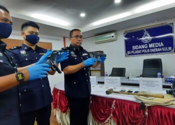 SAZALEE Adam (kiri) menunjukkan pistol tiruan yang dirampas daripada empat suspek yang menyamun sebuah rumah di Kulim. - UTUSAN/AZAHAR HASHIM