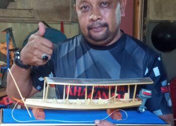 MOHD. SAHFRAN Suran menunjukkan replika bot kajang Tembeling antara kraf tangan yang dihasilkan untuk dijual kepada pelanggan di Taman Desa Gemilang di Jerantut, Pahang. – UTUSAN/HARIS FADILAH AHMAD