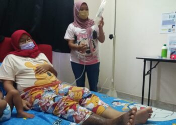 NORSYAFIQAH Anis Mohamad Ahpandi (kiri) dibantu adiknya, Norsyazlina Anis menjalani rawatan dialisis di Flat Alam Perdana, Puncak Alam, Selangor.