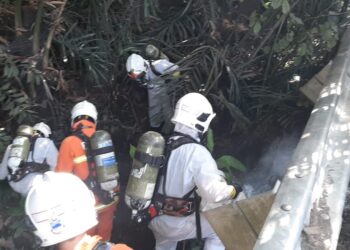 PASUKAN Hazmat memeriksa tahap pencemaran di anak air di lokasi berhampiran sebuah lori tangki yang membawa muatan asid sulfurik yang terbabas di Kampung Juasseh Kapitan, Jalan Lister, Taman Jemapoh, Kuala Pilah hari ini. - UTUSAN/ZAKKINA WATI AHMAD TARMIZI