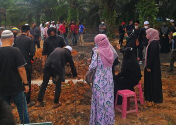 AHLI keluarga arwah Gmie menabur bunga di pusaranya di Tanah Perkuburan Kampung Medan, Kuala Langat, Selangor hari ini. - UTUSAN/ABDUL RAZAK IDRIS