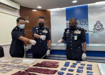 RAMLI MOHAMED Yoosuf (kanan) menunjukkan rampasan pelbagai jenis dadah dan wang tunai diperoleh hasil serbuan terhadap dua suspek yang dipercayai pengedar dadah aktif khususnya di kawasan Felda sekitar Kuantan, Pahang. - UTUSAN/ DIANA SURYA ABD WAHAB