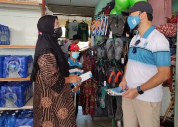 MUKHRIZ Mahathir (kanan) mengedarkan risalah Pejuang kepada peniaga di Arked Niaga Tanjung Dawai, Merbok, Sungai Petani hari ini. - UTUSAN/NUR SYAZWANA MANSOR