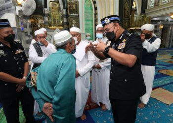 SHAFIEN Mamat beramah mesra dengan jemaah selepas solat Jumaat di Masjid Kubang Batang, Tumpat, Kelantan. - UTUSAN/ROHANA MOHD. NAWI