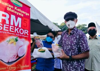 ROSOL Wahid (tengah) menunjukkan ayam yang dijual pada harga serendah RM5 seekor sempena PJKM di pekarangan Masjid Daerah SPT, Bandar Perda, Bukit Mertajam, Pulau Pinang hari ini.