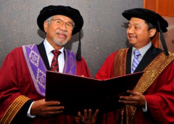 ABDUL Rahim Ramli (kiri) bersama anaknya, Prof. Dr. Kamal selepas menerima ijazah doktor falsafah pada usia 70 tahun dalam Majlis Konvokesyen ke-64 UTM di Skudai, Johor. -UTUSAN/RAJA JAAFAR ALI