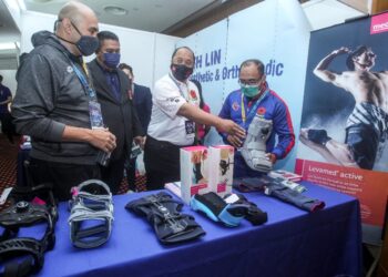 HASNUL Faizal Hushin Amri (kiri) melawat pameran selepas majlis perasmian Simposium Perubatan Ragbi Malaysia 2021 di Menara Seri Wilayah Putrajaya, semalam.- UTUSAN/FAISOL MUSTAFA