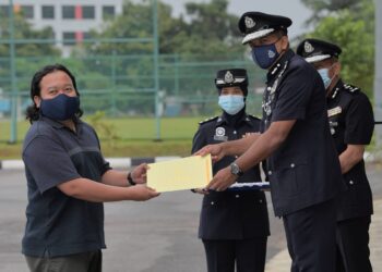 AYOB Khan Mydin Pitchay menyampaikan sijil penghargaan kepada wartawan Utusan Malaysia, Mohamad Faizal Hashim sempena Perhimpunan Bulanan dan Penyampaian Sijil Penghargaan PDRM Kontinjen Johor di Johor Bahru. - UTUSAN/RAJA JAAFAR ALI