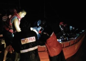 ANGGOTA bomba memindahkan mangsa terjejas banjir di Kota Marudu malam tadi. - IHSAN BOMBA