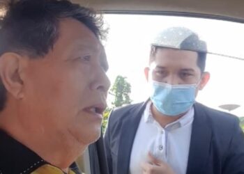 VOON Lee Shan bertikam lidah dengan individu dipercayai pegawai SPRM)di tepi jalan Kenyalang Park, Kuching, Sarawak, pagi ini.