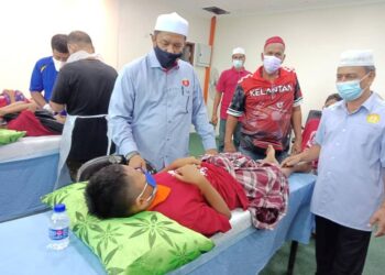 WAN Roslan Wan Hamat berbual dengan salah seorang peserta Program Khitan Perdana DUN Pengkalan Kubor di Tumpat, Kelantan hari ini. - UTUSAN/ROSLIZA MOHAMED