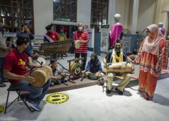 AIDIDAH Ibrahim (kanan) melihat persembahan alat muzik tradisional oleh kumpulan Gendang Warisan Langkawi sempena Langkawi Craft Musical Fest 2021 di Kompleks Kraf Langkawi di Langkawi malam semalam. - UTUSAN/FARIZ RUSADIO