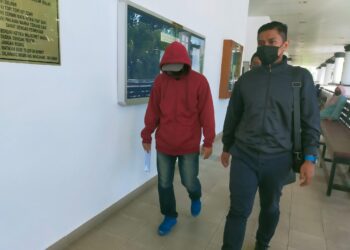 SHARUM Hassim (kiri) yang mengaku tidak bersalah tuduhan menerima rasuah berhubung pemberian kerja pengurusan jenazah dibawa keluar dari Mahkamah Sesyen Alor Setar hari ini. - UTUSAN/MOHD. RAFIE AZIMI