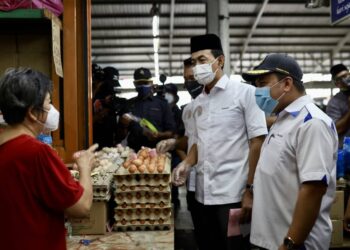 MOHD. Zawawi Ahmad Mughni (tengah) bersama Pengarah KPDNHEP Negeri Selangor, Muhd. Zikril Azan Abdullah (kanan) sedang membuat pemeriksaan barangan dibawah harga kawalan sewaktu program walkabout skim harga maksimum keluarga Malaysia di Pasar Pelabuhan Klang, Selangor pada hari ini. - UTUSAN / ZULFADHLI ZAKI
