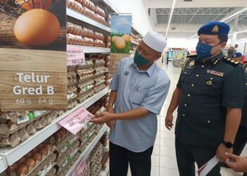 WAN Romani Wan Salim (kiri) bersama Mohd. Sharhan Mohd. Arshad melihat tanda harga telur ayam ketika melakukan walkabout SHMKM di Lotus Kulim, Kulim hari ini. - UTUSAN/AZAHAR HASHIM