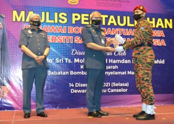 MOHAMMAD Hamdan Wahid (tengah) menyampaikan anugerah Pelatih Keseluruhan Terbaik kepada Muhammad Al Hakim Mohd. Zulkifli pada Majlis Pentauliahan Pegawai Bomba Bantuan Siswa USIM di Dewan Tuanku Canselor USIM, Nilai, Seremban hari ini.-UTUSAN/ZAKKINA WATI AHMAD TARMIZI.