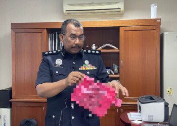 AZLAN Abu menunjukkan kod QR yang dicetak pada beg plastik ketika ditemui pemberita di IPK Melaka, Bukit Beruang, Melaka. - UTUSAN/DIYANATUL ATIQAH ZAKARYA