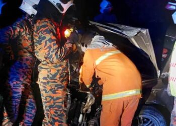 ANGGOTA bomba mengeluar mangsa  kemalangan dari dalam kereta di Kilometer 209.7, Lebuhraya Utara-Selatan arah selatan di Taiping semalam. - UTUSAN/IHSAN JBPM PERAK