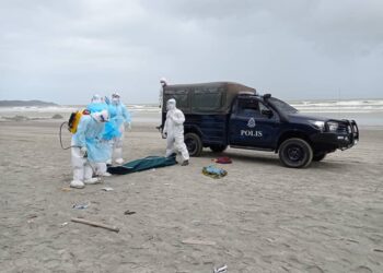 ANGGOTA pasukan penyelamat mengangkat mayat mangsa bot karam yang terdampar di pantai Tanjung Balau, Kota Tinggi di Johor. - UTUSAN/MASTURAH SURADI