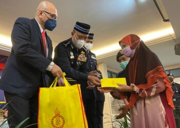 SHAFIEN Mamat bersama Mohd Riduan Junoh (kiri) menyampaikan bantuan kepada pesara polis di Sudara Beach Resort, Bachok, Kelantan hari ini. - UTUSAN/TOREK SULONG