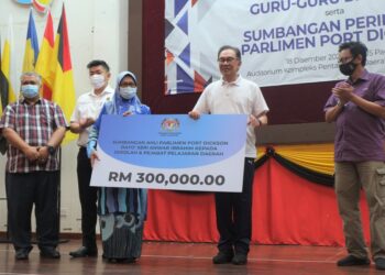 ANWAR Ibrahim menyerahkan  sumbangan beliau kepada Pengerusi Persatuan Ibu Bapa dan Guru (PIBG) Daerah Port Dickson, Arah Abu Bakar pada majlis Ramah Mesra Bersama Guru-Guru dan PIBG serta Sumbangan Peringkat Parlimen Port Dickson di Kompleks Pentadbiran Daerah Port Dickson hari ini.-UTUSAN/BADRUL HAFIZAN MAT ISA
