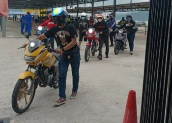 SEBAHAGIAN penunggang menolak motosikal untuk diperiksa oleh polis sejurus tiba di Kompleks Dermaga Tanjung Lembong, Langkawi semalam.