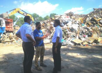 MOHD. Rashidi Ruslan (kanan) mendengar taklimat di stesen transit sampah banjir di Seksyen 21 di Shah Alam, Selangor, hari ini. - UTUSAN/ABDUL RAZAK IDRIS