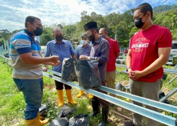NIK MUHAMMAD Zawawi menyantuni seorang Wira Agro yang terjejas akibat banjir di Hulu Langat, Selangor. – JABATAN PERTANIAN