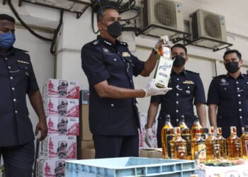 VIJAYA Rao Samachulu (tengah) menunjukkan arak tiruan yang dirampas pada sidang akhbar kejayaan polis menumpaskan kilang minuman keras tiruan di Ibu pejabat Polis Daerah Klang Utara. - UTUSAN/ZULFADHLI ZAKI