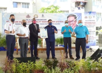 AYUB Jamil (tiga dari kanan) menunjukkan sijil ISO 9001:2015 yang diterima Perbadanan Pengurusan Pinang 3, Taman Daya, di Johor Bahru.