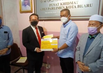 TAKIYUDDIN Hassan (dua dari kanan) menyampaikan sumbangan kepada seorang penerima di Pusat Khidmat Ahli Parlimen Kota Bharu, di sini hari ini. - UTUSAN/ROHANA MOHD. NAWI