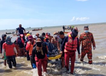 PASUKAN bomba mengangkat mayat mangsa lemas yang ditemukan di Pantai Palakat, Sipitang petang tadi. - IHSAN BOMBA