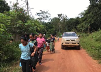 PELAJAR Orang Asli dibawa menaiki kenderaan bagi memulakan sesi persekolahan di Gua Musang, Kelantan hari ini. - UTUSAN/AIMUNI TUAN LAH