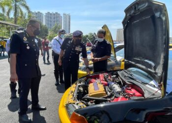 ABDUL MAJID Mohd. Ali (tengah) memeriksa enjin sebuah kereta yang ditunda ke IPK Melaka, Bukit Beruang, Melaka. - UTUSAN/DIYANATUL ATIQAH ZAKARYA