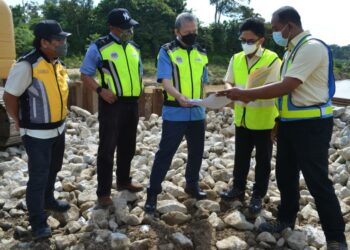 FADILLAH Yusof (tengah) melihat pelan pembinaan jambatan Bailey yang di Kampung Bemban, Simpang Durian, Jelebu hari ini. - UTUSAN/ZAKKINA WATI AHMAD TARMIZI