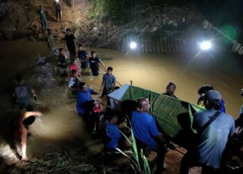 PENDUDUK Kampung Sungai Rotan Jelebu bersama mengusung jenazah merentasi sungai untuk dikebumikan di Tanah Perkuburan Islam Kampung Sungai Rotan selepas jambatan yang menjadi laluan sebelum ini runtuh akibat banjir. - GAMBAR/FACEBOOK JALALUDDIN ALIAS