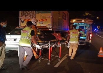 DR. Mohd Saiful Mohd. Said (kiri) turut membantu pihak bomba memberikan rawatan kepada seorang mangsa kemalangan di Jalan Seremban-Kuala Pilah dekat Bukit Putus, Kuala Pilah malam tadi.
