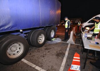 ANGGOTA JPJ memeriksa timbang berat salah sebuah lori yang ditahan dalam Operasi Halangan di Hentian Senawang, Lebuh Raya Utara Selatan (arah utara) di Seremban malam tadi.-UTUSAN/MOHD. SHAHJEHAN MAAMIN.
