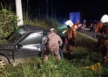 PASUKAN bomba mengeluarkan mangsa yang tersepit dan meninggal dunia di Jalan Tenom Sapong, Tenom pagi ini. - IHSAN BOMBA
